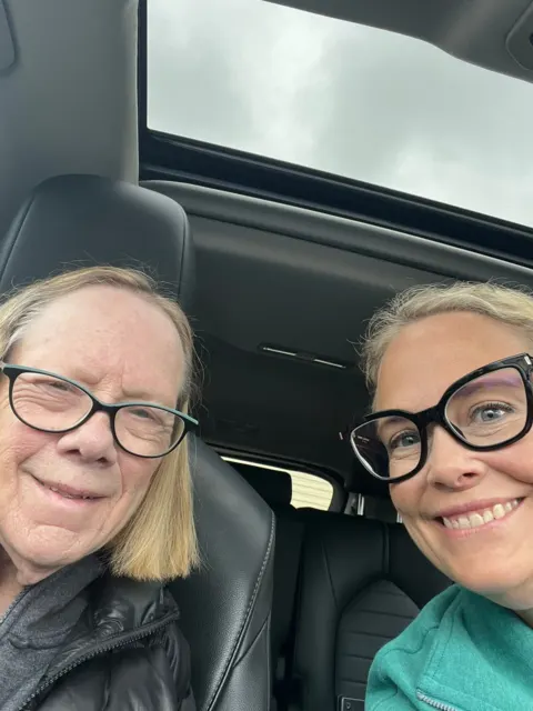 Resident and companion smiling during a car trip at AAA Shepherd’s Care Home