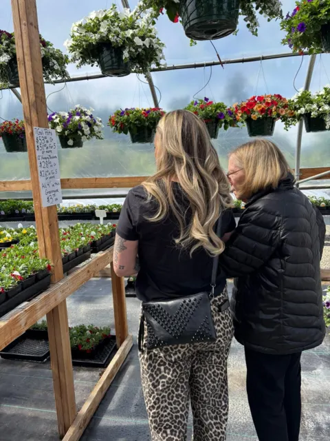 Resident and companion visiting a garden nursery at AAA Shepherd’s Care Home