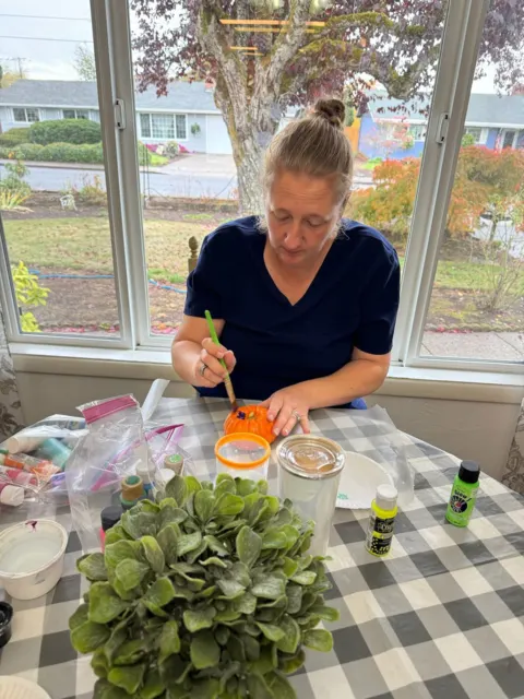 Resident arranging flowers at the table at AAA Shepherd’s Care Home