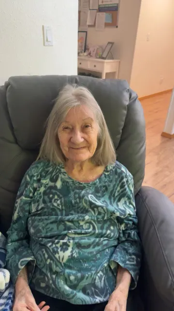 Resident relaxing in a patterned green top at AAA Shepherd’s Care Home