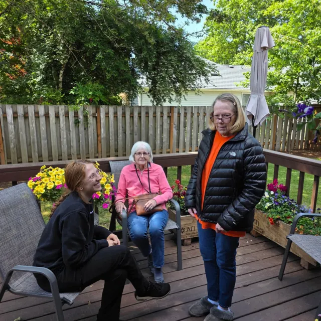 Residents and staff chatting on the garden deck at AAA Shepherd’s Care Home