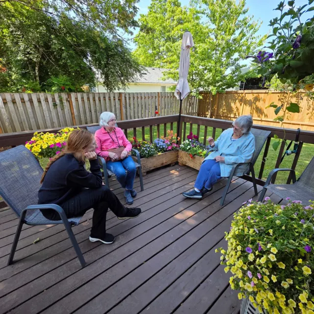 Residents chatting together on the garden deck at AAA Shepherd’s Care Home