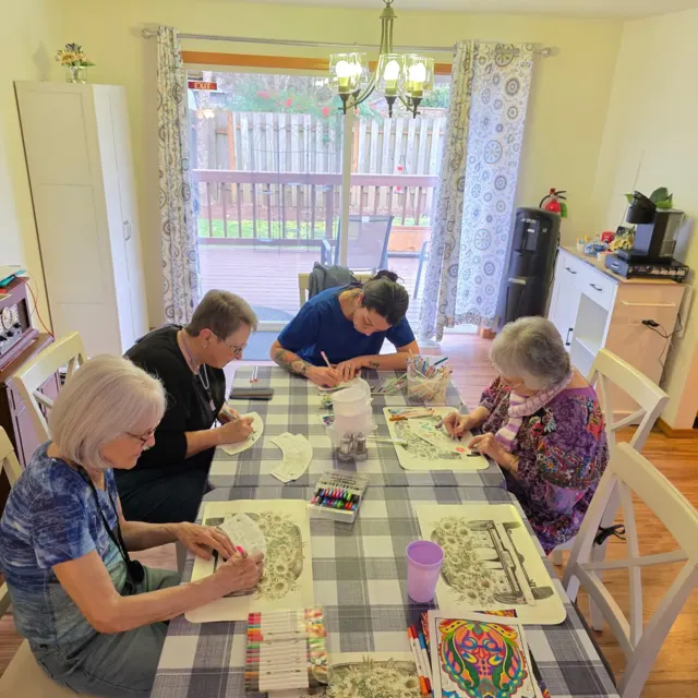 Residents enjoying a group activity at the table at AAA Shepherd’s Care Home
