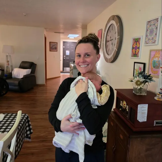Staff member holding a baby at AAA Shepherd’s Care Home